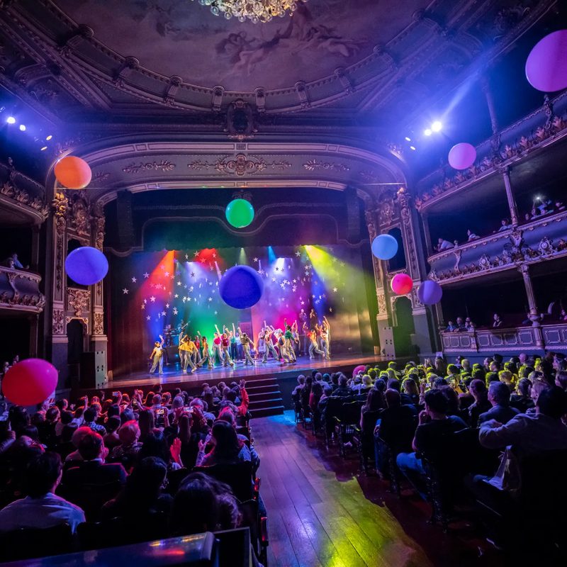 Still Standing 2026 — vista de la sala del teatro con globos de colores y el público
